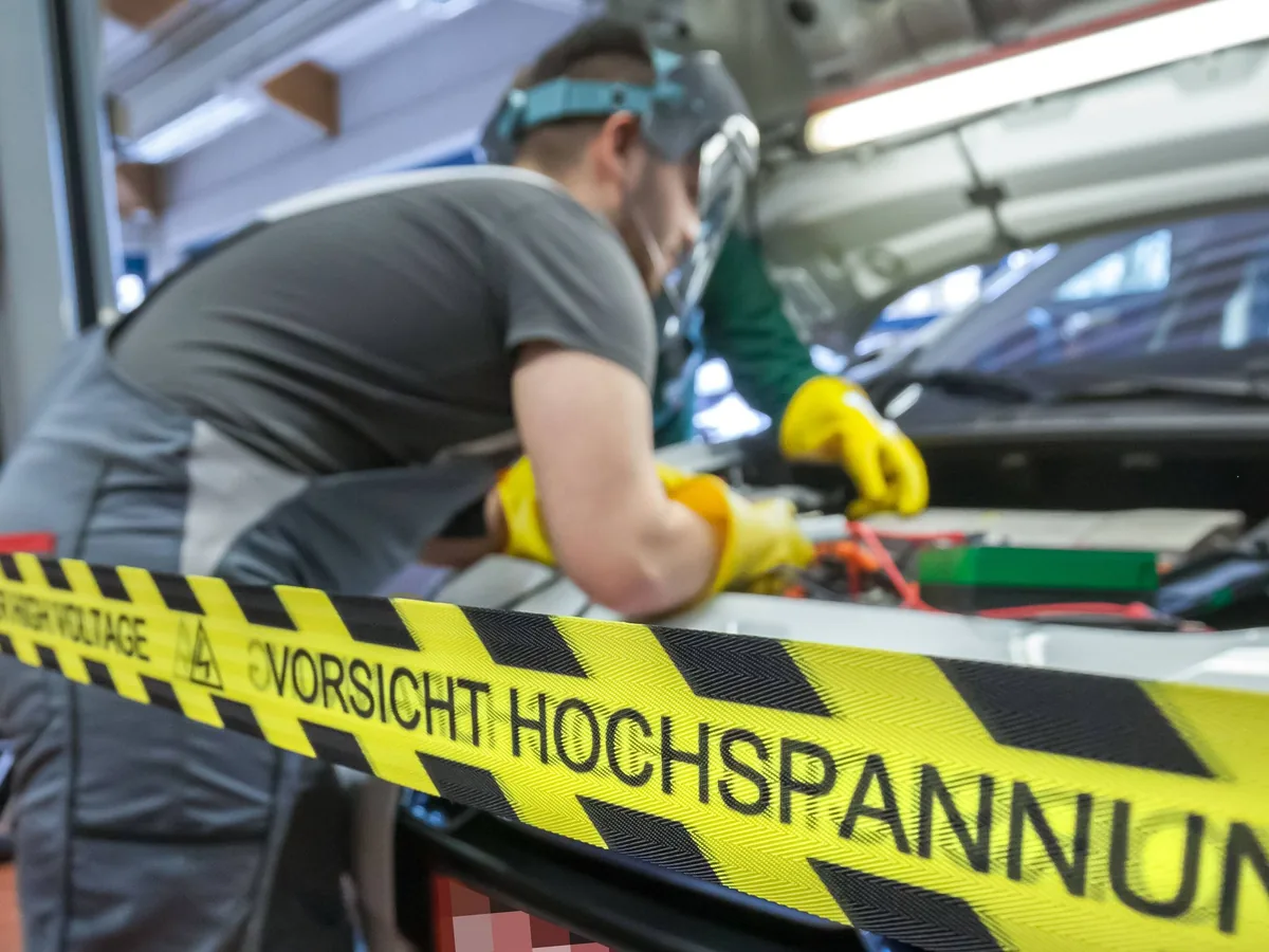 Belt displaying the German warning “Vorsicht Hochspannung” (“Caution: high voltage”) in a workshop